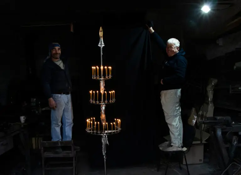 The Art of MFF | "The Cross of Peace" project featuring the Golden Crucifixion. | Sergey Melnikoff and Viktor Bielchyk present the "Spear of Longinus," surrounded by lit church candles, an integral element of the installation.