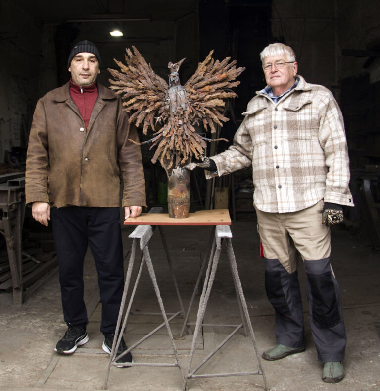 Sergey Melnikoff (right) and Viktor Bielchyk at the entrance to their Odesa workshop, presenting the "Ukrainian Phoenix" sculpture in its final stage of creation.