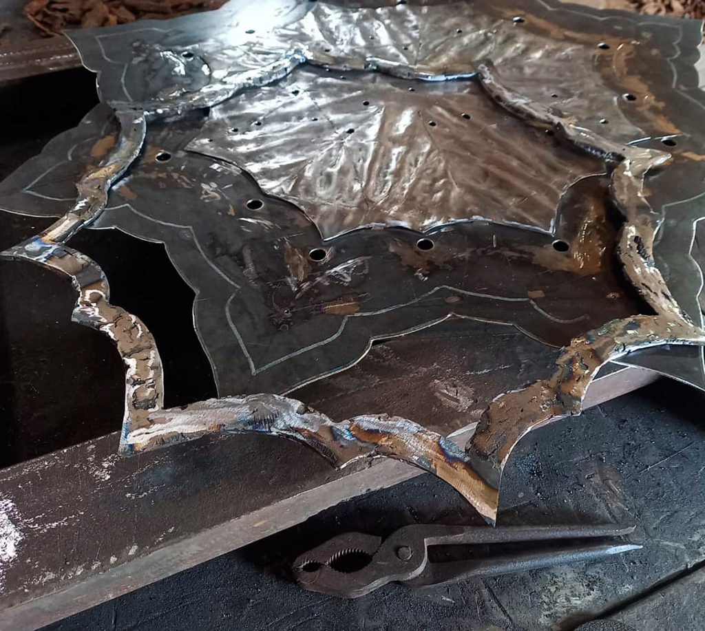 For the first layer of the frame, large curved fragments are selected, welded together, and mechanically smoothed into a single plane.