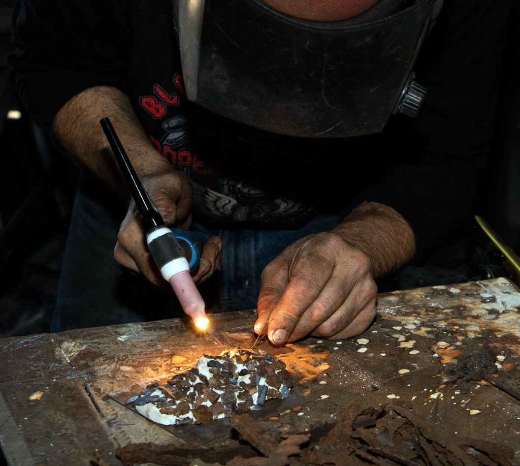 The Arts of MFF | The creation of the Christ figure begins with the careful arrangement of the first layer of fragments. MFF Archive