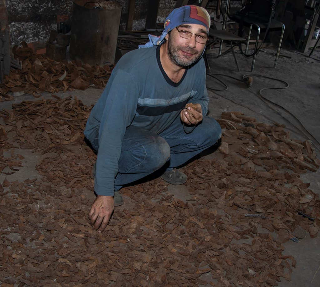 The Art of MFF | Viktor Bielchyk, master welder and collaborator of Sergey Melnikoff (MFF), examining shrapnel fragments delivered from the front lines at his workshop in Odesa, 2023. Photo by Mariia Universaliuk
