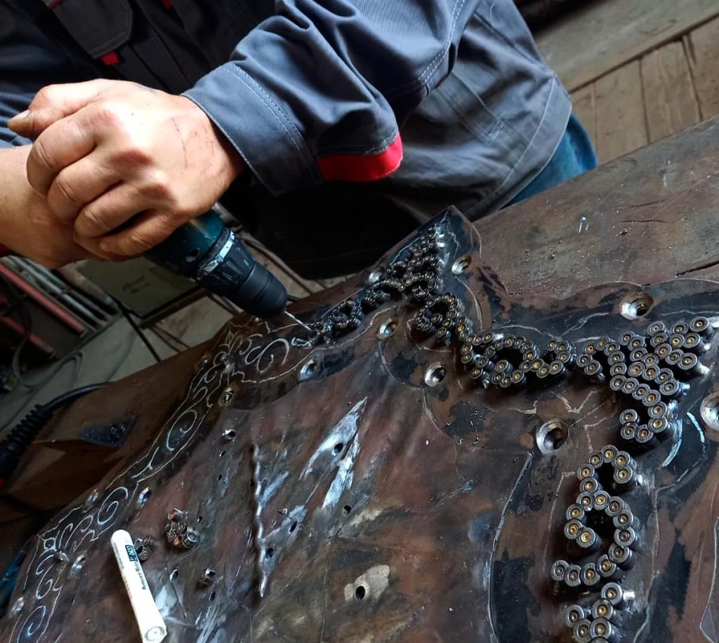 Fragments of war become ornament. Master assembles part of the decorative border of the sculptural composition “Allah al-Akbar”.